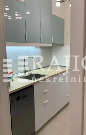 Small modern kitchen with white and blue cabinets.