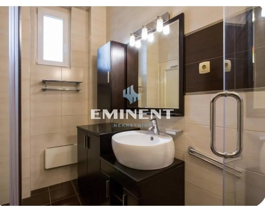 Bathroom equipped with a washbasin, mirror, and shower enclosure.