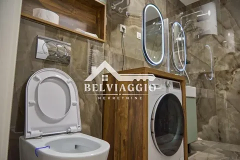 Modern equipped bathroom with a walk-in shower, wall-hung toilet, and washing machine. - image 19
