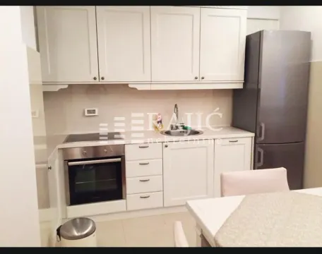 Furnished kitchen with white cabinetry and a dining table. - image 4