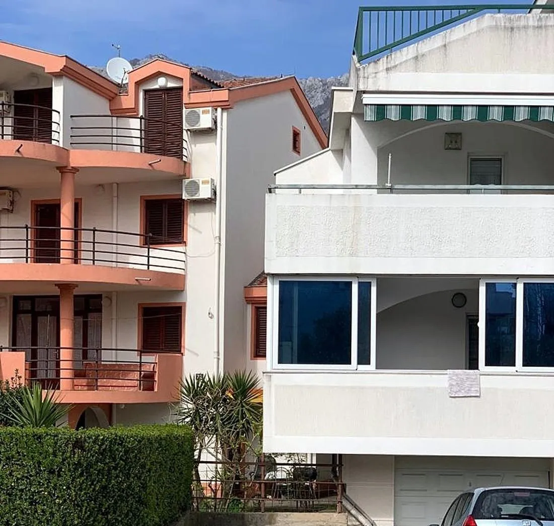 View of the exterior of an apartment building with balconies and greenery.
