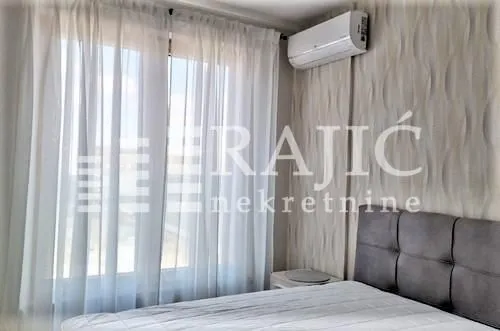 Furnished bedroom with a bed and an air conditioner.
