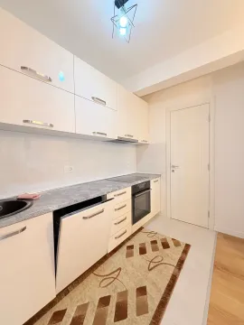 Svjetla kuhinja sa bijelim elementima i ugrađenim aparatima. - image 4