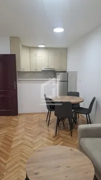 Living room with a dining area and a kitchen in the background. - image 3