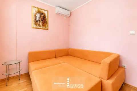 Dnevna soba sa ugaonom garniturom narandžaste boje i slikom konja na zidu. - image 16