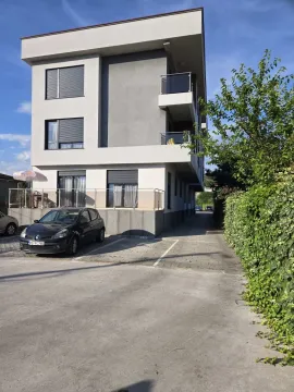 Exterior of a modern residential building with a parking space in front. - image 10