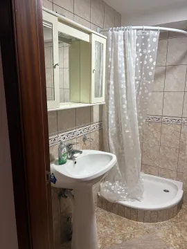 Small bathroom with a sink, mirror, and shower cabin. - image 5