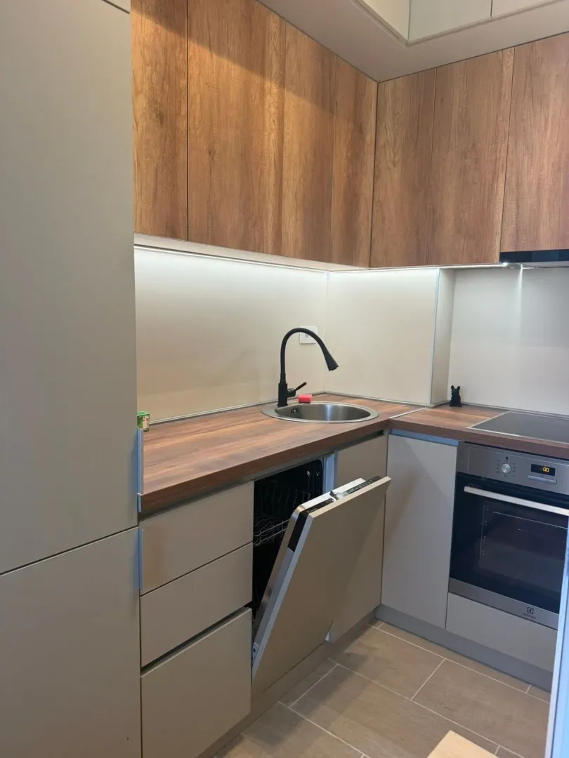 Modern kitchen with wooden elements and built-in appliances.