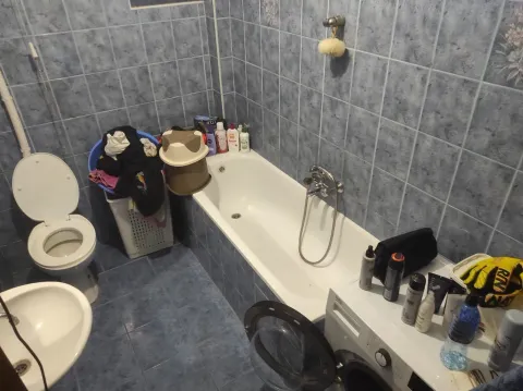 A simple bathroom with blue tiles and a bathtub. - image 8