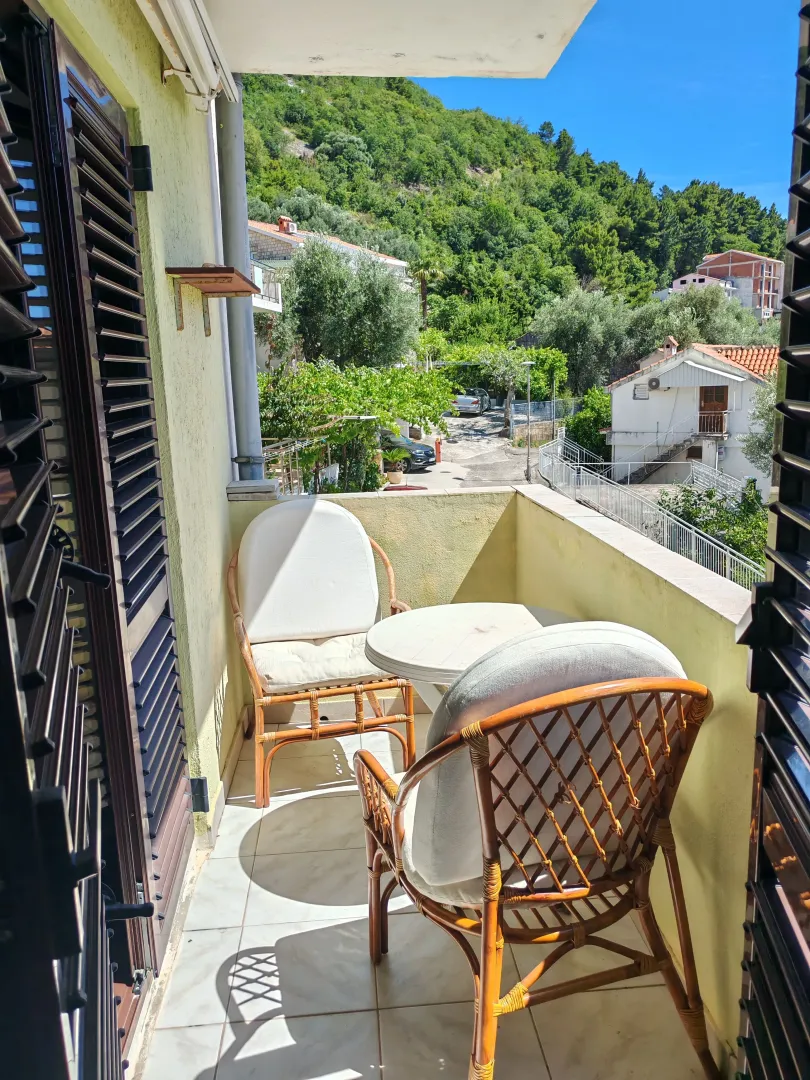 Namješten balkon sa garniturom za sjedenje i pogledom na zelenilo.