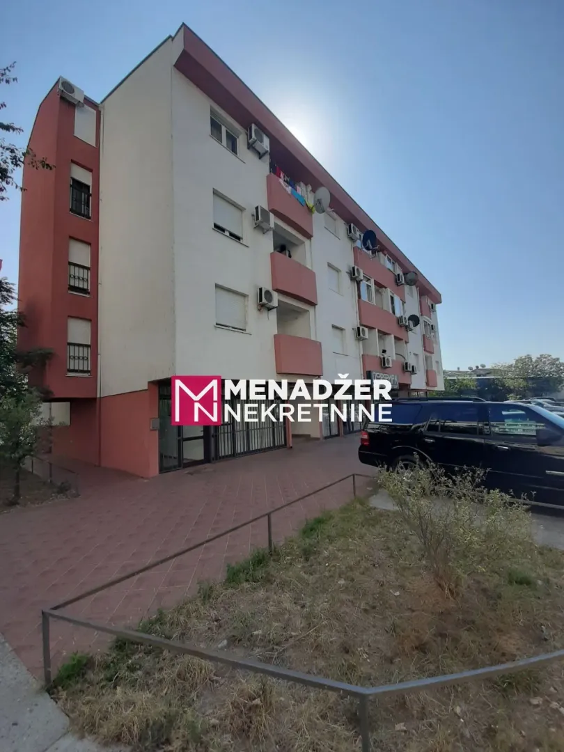 Exterior view of an apartment building with a paved courtyard.