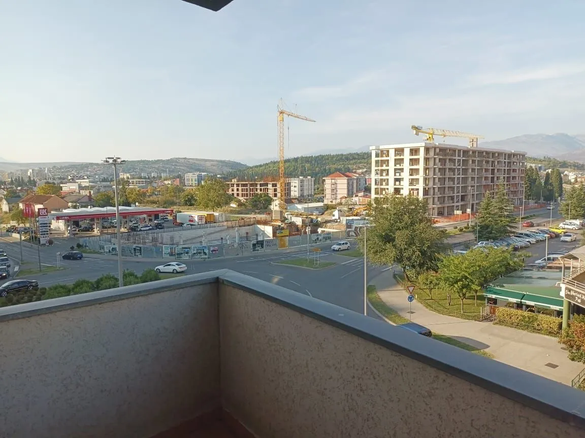 Pogled sa terase na okolne zgrade, saobraćajnicu i gradilište.