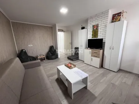 Dnevna soba sa garniturom, TV komodom i belim zidnim pločicama. - image 3