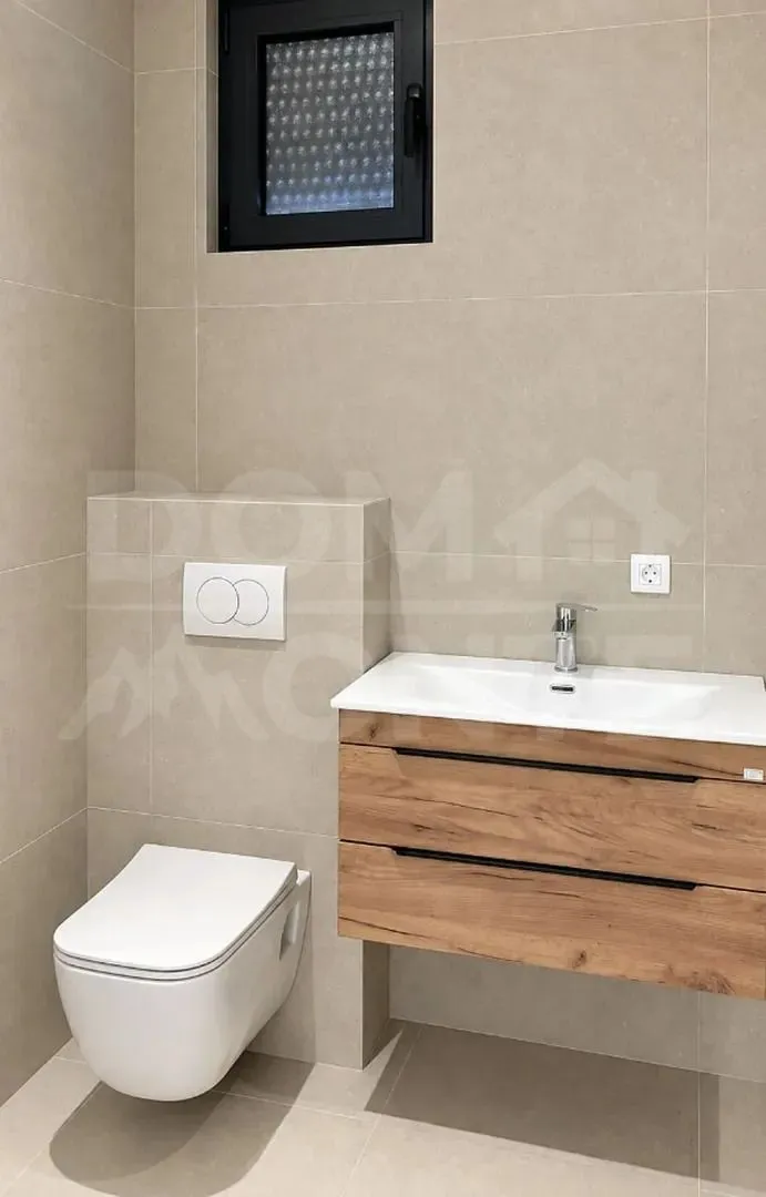 Moderno opremljeno kupatilo sa sanitarijama i umivaonikom.