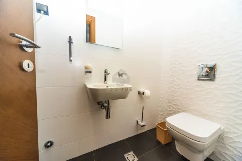 Manje kupatilo sa bijelim pločicama, umivaonikom i toaletnom šoljom. - image 10