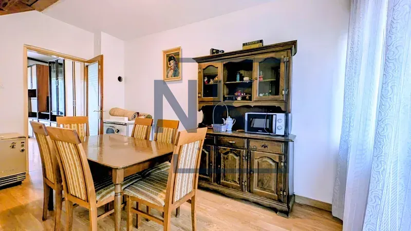 Dining room with a wooden table, chairs, and a large display cabinet.