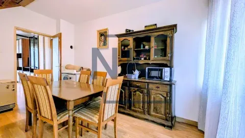 Dining room with a wooden table, chairs, and a large display cabinet. - image 4