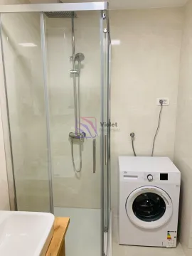 Bathroom with a shower cabin and a washing machine. - image 8