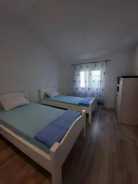 Spavaća soba sa dva kreveta samca i ormarom. - image 4
