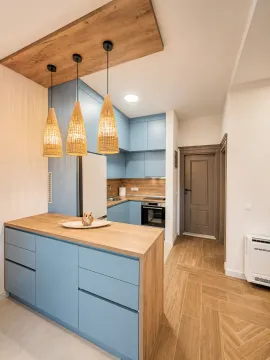 Modern kitchen with blue cabinets, wooden countertop and pendant lights. - image 7