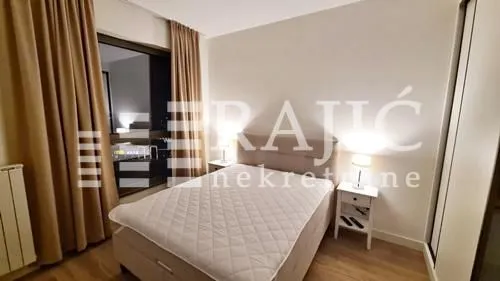 Furnished bedroom with a double bed, nightstands, and a wardrobe.