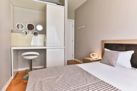 Modern bedroom with a double bed and a built-in wardrobe with a vanity desk. - image 4