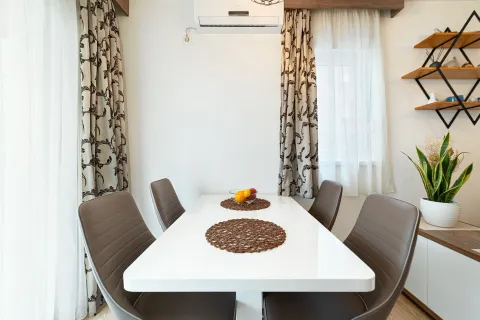 Dining area with a white table and grey chairs. - image 11