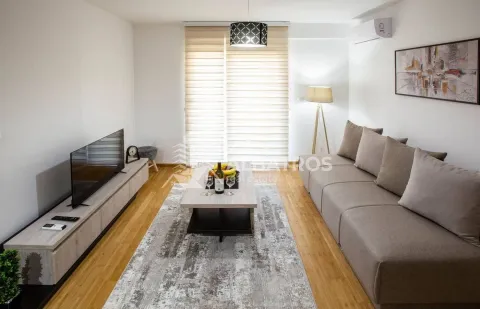 Living room with a sofa, TV, and coffee table in bright tones. - image 2