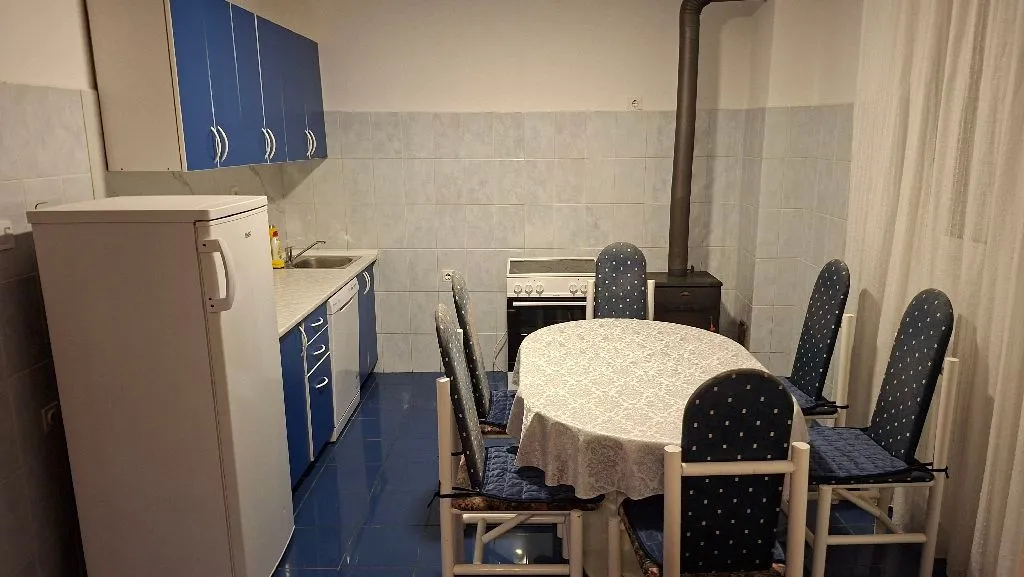 Kitchen with dining area equipped with blue cabinets and a table with chairs.