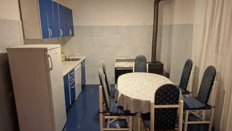 Kitchen with dining area equipped with blue cabinets and a table with chairs. - image 4
