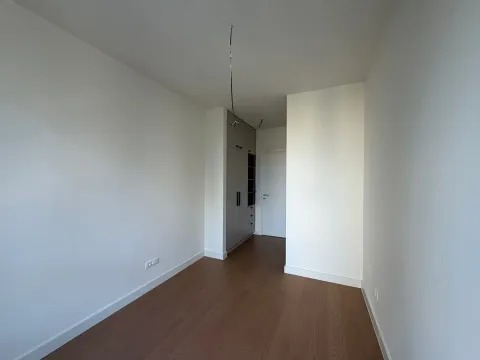 Prazna prostorija sa drvenim podom, ugradnim ormarom i belim zidovima. - image 3
