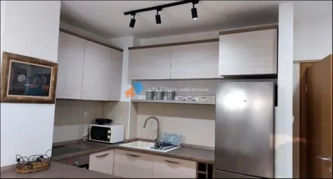 Small equipped kitchen with white cabinetry and a refrigerator. - image 5