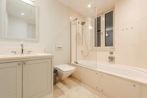 Svijetlo kupatilo sa umivaonikom, ugrađenim wc šoljom i kadom sa staklenom pregradom. - image 16