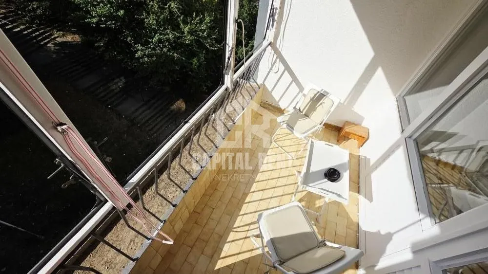 Small enclosed balcony space with chairs and a table.