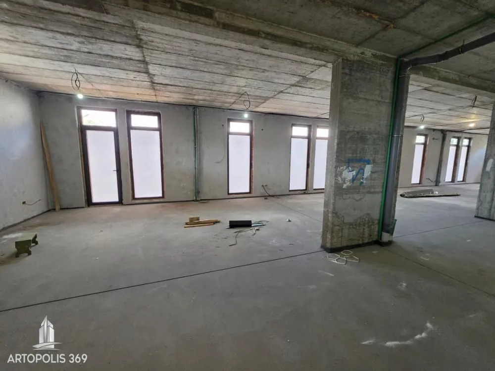 View of an empty space under construction with concrete pillars and windows.