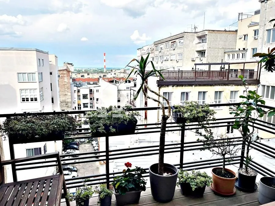 Furnished terrace with potted plants and city view.