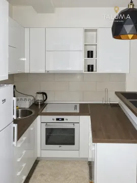 Small white kitchen with wooden countertops and built-in appliances. - image 3