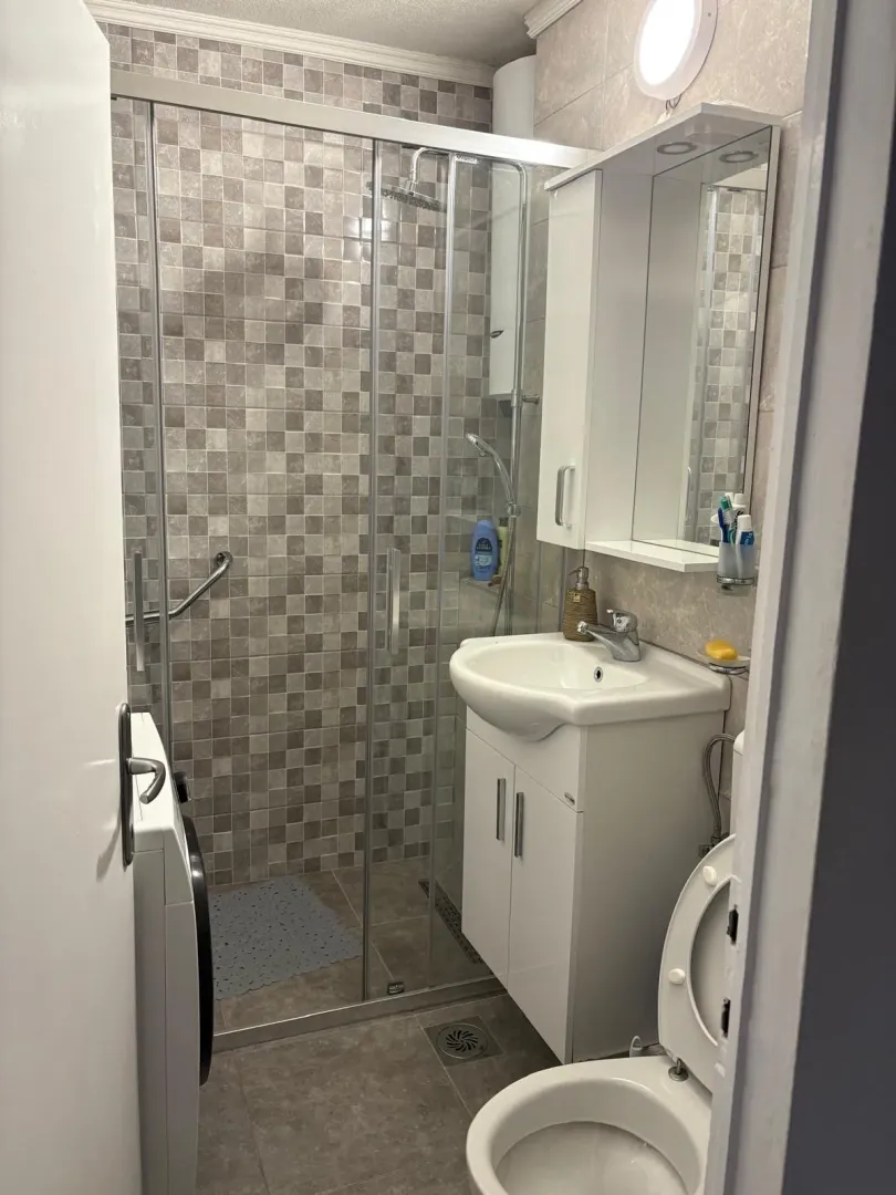 Simple bathroom with a shower cabin and sink.