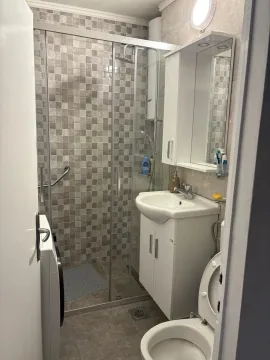 Simple bathroom with a shower cabin and sink. - image 15