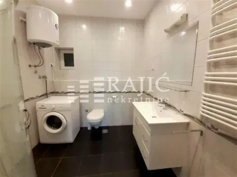 Fully equipped bathroom with a washbasin, washing machine, and toilet. - image 13