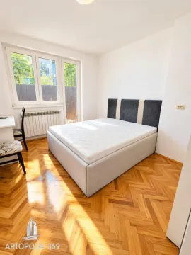 Nameštena spavaća soba sa bračnim krevetom, parketom i prozorom koji gleda spolja. - image 3