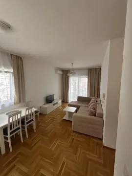 Living room with dining area and parquet flooring. - image 2
