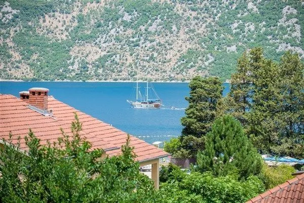 Pogled na more i planine sa krovovima kuća.