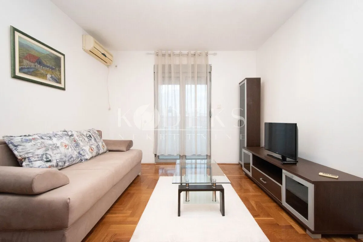 Living room furnished with a sofa, TV, and coffee table.