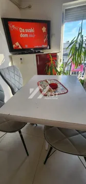 Dnevni boravak sa trpezarijskim stolom i televizorom na zidu. - image 7