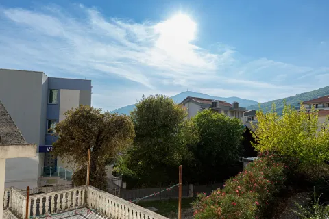 View from the terrace towards surrounding buildings, trees, and mountains in the background. - image 13