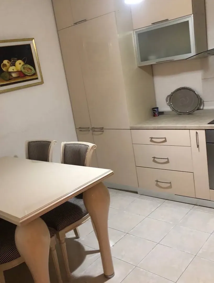 Kitchen with a dining table and beige kitchen cabinets.