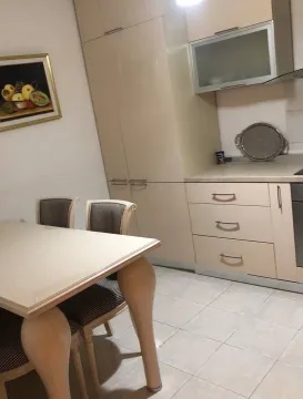 Kitchen with a dining table and beige kitchen cabinets. - image 6
