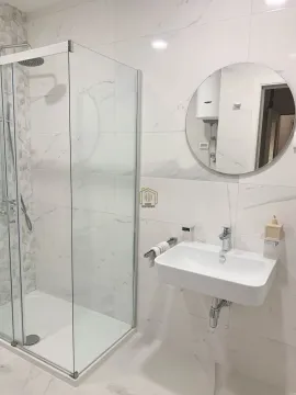 Moderne kupatilo sa tuš kabinom, umivaonikom i okruglim ogledalom. - image 7