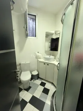 A compact bathroom with a shower cabin, washbasin, and toilet. - image 2
